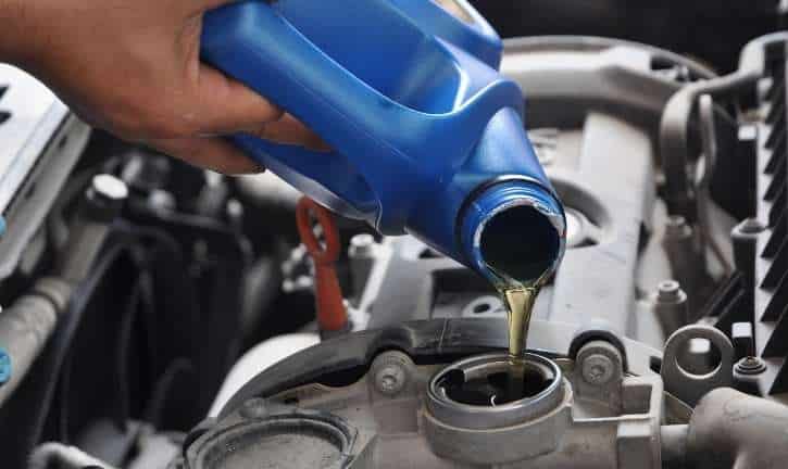 Person adding oil to boat engine.