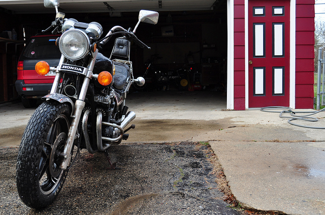 Motorcycle stored outside of a garage.