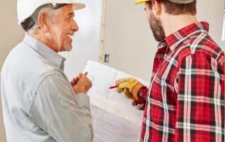 Two men reviewing construction plans for home remodel.