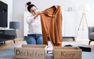 Women sorting clothing in declutter and keep boxes.