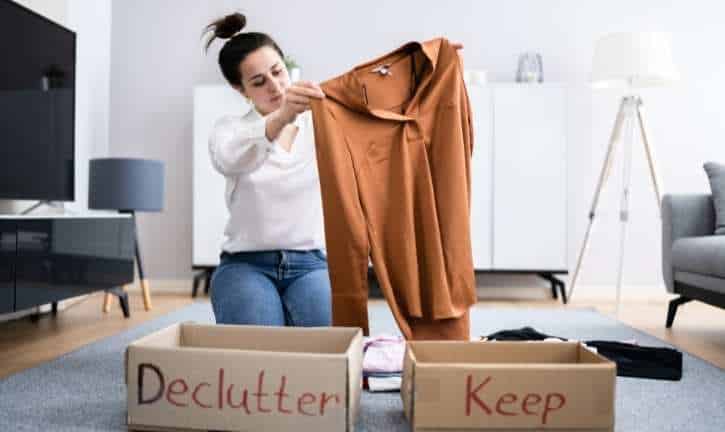 Women sorting clothing in declutter and keep boxes.