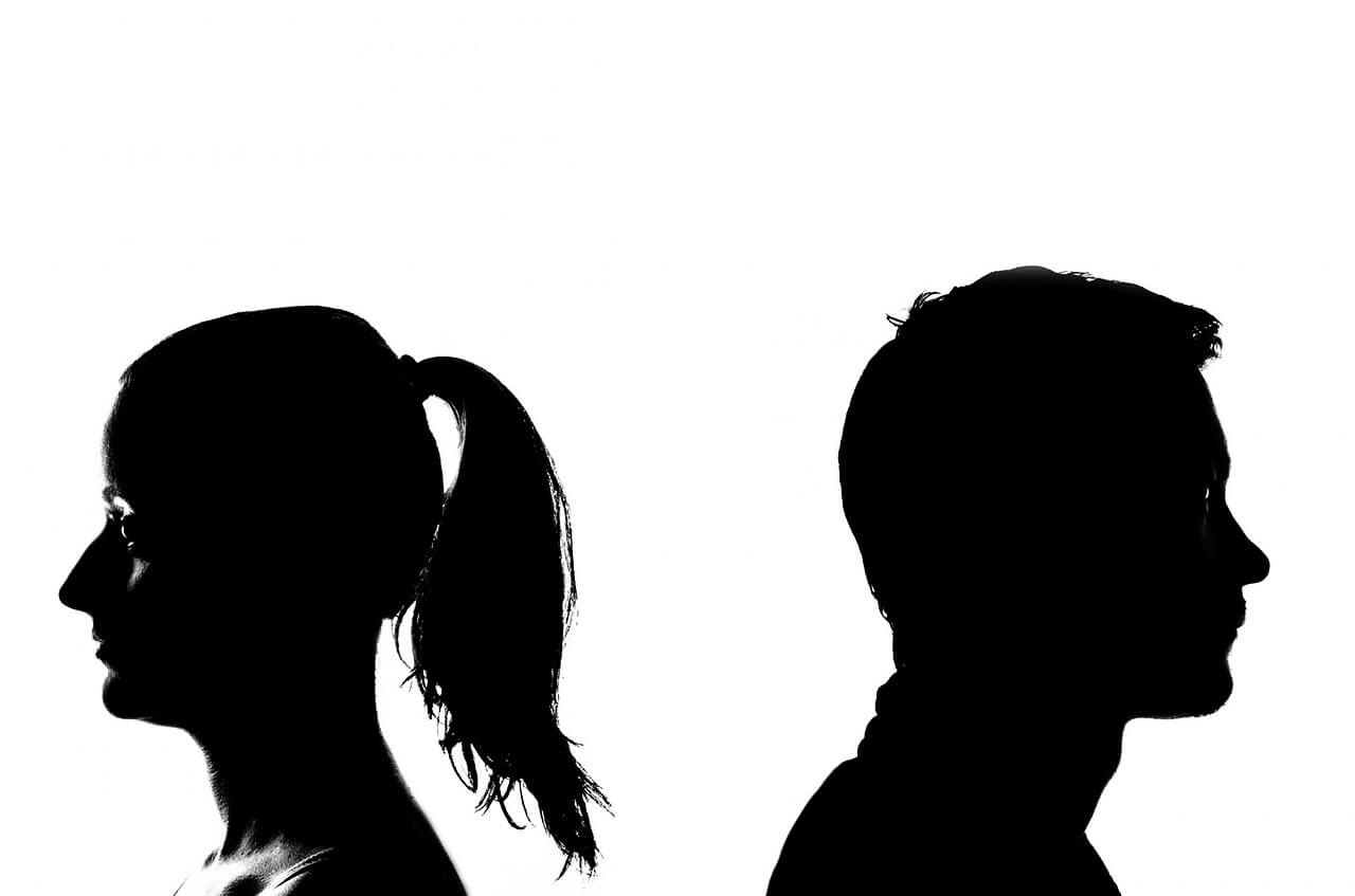 black silhouette of a man and woman standing back to back