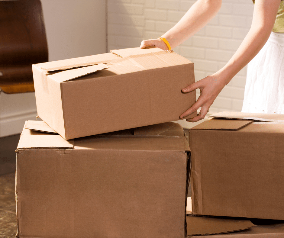 Person stacking boxes in a college dormitory.