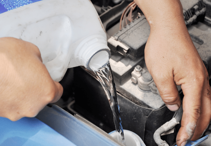 Filling window washer fluid in car.