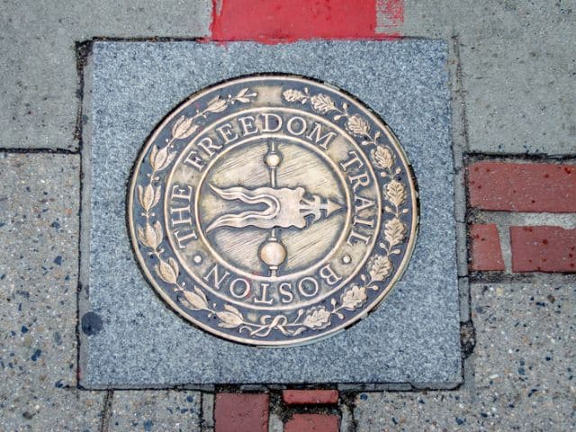 Metal marker on the sidewalk for the Freedom Trail in Boston.