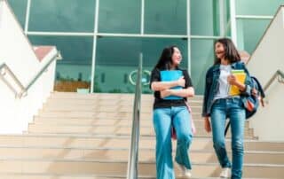 two college students walking down the steps at a building