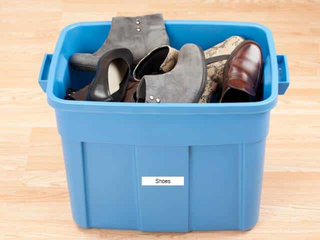 Blue storage tub with shoes inside.
