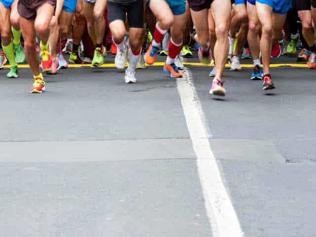 Photo of many legs at the start of a marathon.