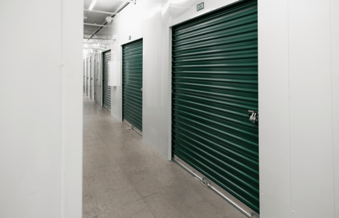 row of storage units with green doors.