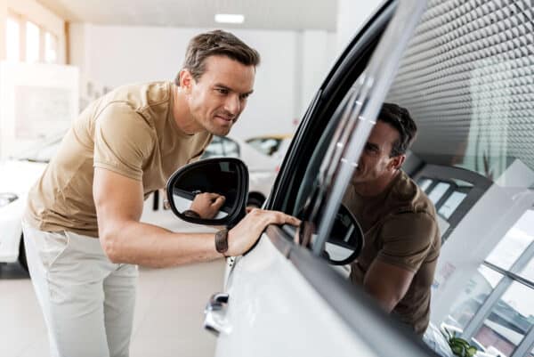 man looking into a car's window